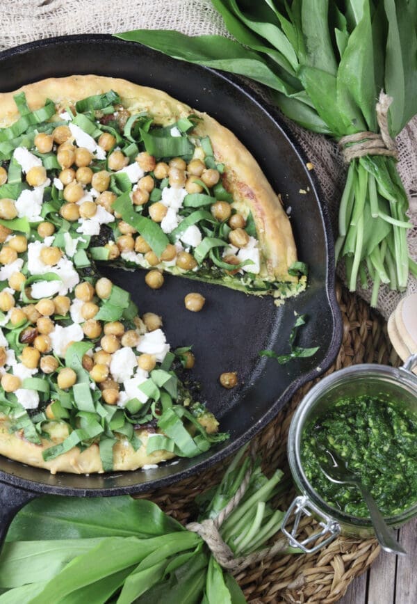 image of wild garlic pizza with chickpeas in a cast iron pan